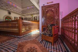 Habitación con escalera, silla y alfombra. en Riad Alhambra en El Harhoura