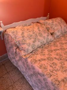 a bed in a bedroom with a bedspread with flowers at La Clementina in San Clemente del Tuyú