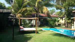 a swing in a yard next to a swimming pool at Casa Da Duda in Arraial d'Ajuda