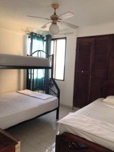 a bedroom with two bunk beds and a ceiling fan at Departamento 4 habitaciones 12 personas vista al mar 8vo piso Playa Almendro in Tonsupa