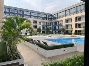 a large building with a swimming pool in front of it at Central Studio Suite at Embassy Gardens in Accra