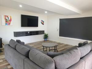 a living room with a large couch and a flat screen tv at Heinlen on Bridges Street in Mount Gambier