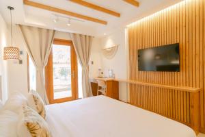 Un dormitorio con una cama y un televisor en una pared. en LEUX Hotel Alona Panglao, en Panglao