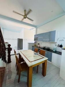 una cucina con tavolo, sedie e ventilatore a soffitto di KEN Homestay a Cu Lao Thu