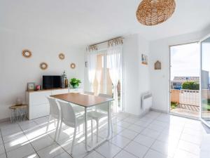 a kitchen and dining room with a table and chairs at Pavillon 3 pièces avec vue mer, piscine et terrasse, animaux admis - FR-1-409-278 in Fleury