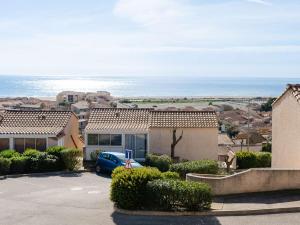 a house with a blue car parked in a parking lot at Pavillon 3 pièces avec vue mer, piscine et terrasse, animaux admis - FR-1-409-278 in Fleury
