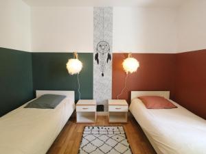 - 2 lits dans une chambre avec 2 lampes et un tapis dans l'établissement Gîte familial entre Angers et Saumur - FR-1-622-104, à Saint-Sulpice