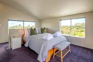 a bedroom with a large bed with towels on it at The Sanctuary Couples Retreat in Waiheke Island