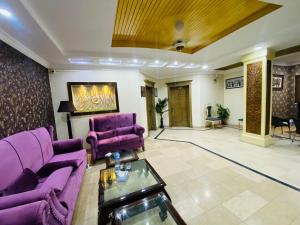 een woonkamer met paarse banken en een tafel bij Family lodges in Islamabad