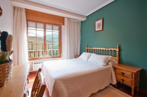 a bedroom with a bed and a window at Apartamentos Casa Paulino in Taramundi