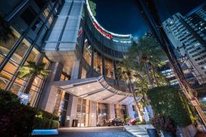 a tall building with palm trees in front of it at Bangkok Marriott Hotel Sukhumvit in Bangkok
