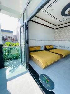 a bedroom with two beds and a balcony at Cactus Homestay Ninh Thuan in Kinh Dinh