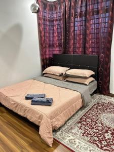 ein Bett mit einer Fernbedienung darauf in der Unterkunft Aisyahmuslim Homestay Putrajaya in Putrajaya