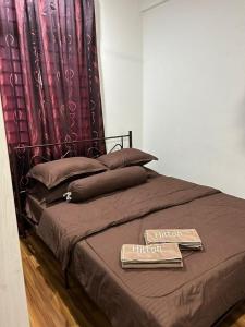 ein Bett mit einer braunen Decke und ein Schild drauf in der Unterkunft Aisyahmuslim Homestay Putrajaya in Putrajaya