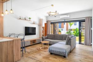 ein Wohnzimmer mit Sofa und Tisch in der Unterkunft Villa Aelia - 3 chambres - Piscine privée. in Flic-en-Flac