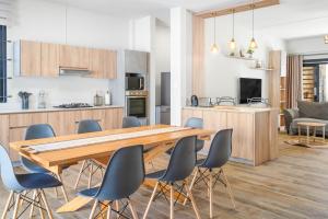 eine Küche und ein Esszimmer mit einem Holztisch und Stühlen in der Unterkunft Villa Aelia - 3 chambres - Piscine privée. in Flic-en-Flac