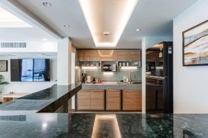 a kitchen with marble countertops and wooden cabinets at PureLux6 - 3BR Pool Villa in Chiang Mai