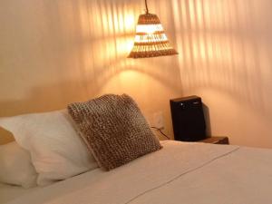 a bedroom with a bed with a pillow and a lamp at Tayrona de Lujo in Santa Marta