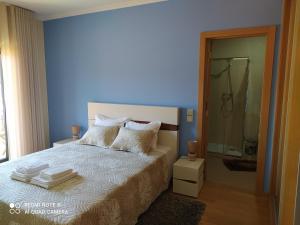 a blue bedroom with a bed with towels on it at BellaVista Alojamento in Arouca +17 photos