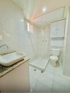a white bathroom with a toilet and a sink at Exclusivo Apartamento en Lecherías 1 min caminando hasta la playa in El Morto de Barcelona