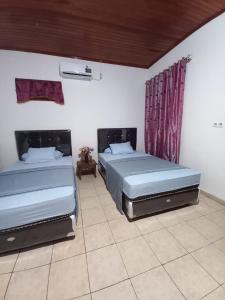 two beds sitting in a room with at Bunaken Blesshi Guest House in Bunaken +31 photos