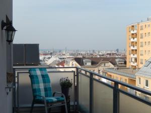 ウィーンにあるPanorama Apartment Viennaの市街の景色を望むバルコニー(椅子付)