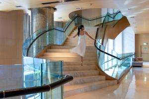 a woman in a white dress walking down stairs at Bangkok Marriott Hotel Sukhumvit in Bangkok