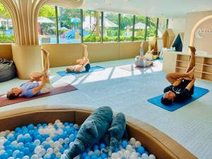 un grupo de niños haciendo yoga en una habitación con pelotas en LaVita, en Phuket