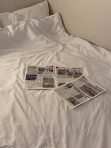 two newspapers sitting on top of a bed at Ban Stay in Daegu