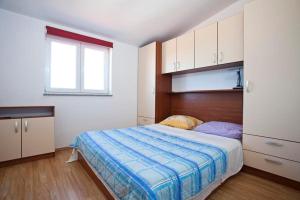 Schlafzimmer mit einem Bett, Schränken und einem Fenster in der Unterkunft Apartments Villa Leona in Betina