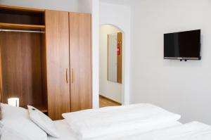 a bedroom with a bed and a television at Hotel Blaue Traube in Schongau