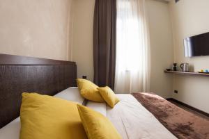 a bedroom with a bed with yellow pillows and a window at Arena Luxury Rooms in Verona