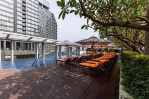 a row of benches with umbrellas on a deck at Bangkok Marriott Hotel Sukhumvit in Bangkok