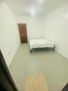 a white room with a bed and a door at Inn Convenience in Coron