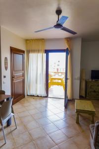 sala de estar con ventilador de techo y mesa en Aparthotel Tropical Bounty Beach B11, en Santa Maria