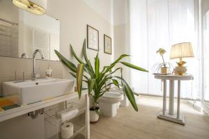 La salle de bains est pourvue d'un lavabo, de toilettes et d'une plante. dans l'établissement Babbo Guest House, à Rome
