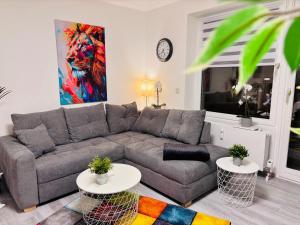 a living room with a gray couch and a painting at MeerZeit in Dahme