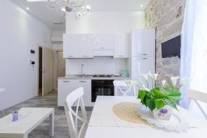 a kitchen with white cabinets and a white table and chairs at Dream Holiday Apartment in Dubrovnik