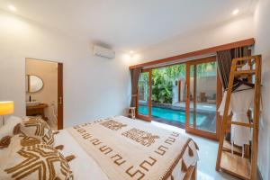 a bedroom with a bed and a view of a pool at Kemiri Villa Lembongan in Nusa Lembongan +22 photos