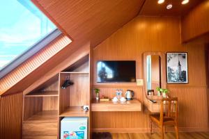 una stanza con una scrivania e una TV a parete di Lotus Hotel Đà Lạt a Khu Chi Lăng