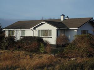 a white house on top of a hill at Woodside Guest House in Stornoway