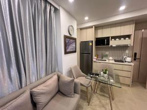 a living room with a couch and a glass table at City Garden Olympus Condo By Vacation Vibes in Pattaya South