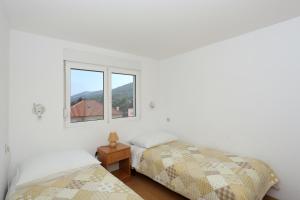 a bedroom with two beds and a window at Apartments Olga in Božava