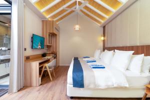 a bedroom with a bed and a desk in a room at ARIA Beach, Ukulhas in Ukulhas