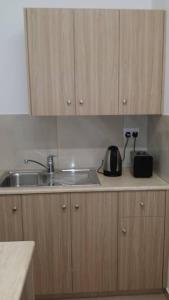 a kitchen counter with a sink and a tea kettle at Simos Magic Hotel Apts in Ayia Napa