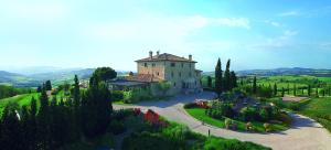 un grand bâtiment sur une colline plantée d'arbres et de fleurs dans l'établissement Relais Todini, à Todi