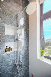 una doccia con una porta in vetro in un bagno di Lotus Hotel Đà Lạt a Khu Chi Lăng Altre 37 foto