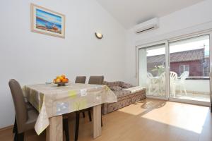 a dining room with a table and a couch at Apartments Olga in Božava