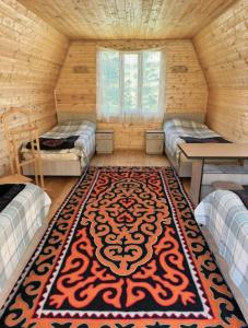 a room with two beds and a rug in a room at Bosogo Resort in Pervomayskoye