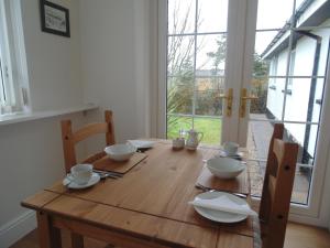 a wooden table with bowls and plates on it at Woodside Guest House in Stornoway